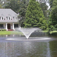 Kasco 3/4HP Aerating Fountain 3400VFX with V-Shape Pattern Operating in a Pond in Front of a  White House with Trees
