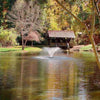 Image of Scott 1/2HP Display Aerator Operating in a Pond with Trees and a Cottage at the Back DA-20 14020