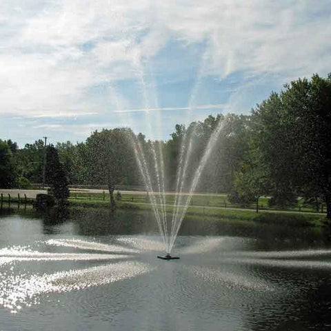 Scott 1-1/2HP Pond Fountain with Belcrest Pattern Operating in a Pond with Trees at the Back 13014