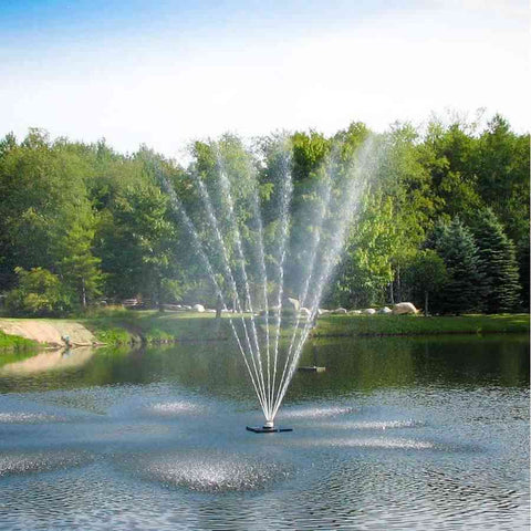 Scott 1-1/2HP Pond Fountain with Belcrest Pattern Operating in a Pond with Trees at the Back 13014