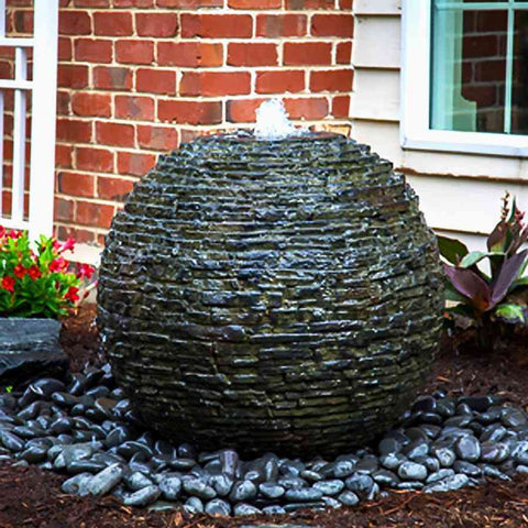 Aquascape Medium Stacked Slate Sphere Landscape Fountain Kit Operating Beside a House 78290