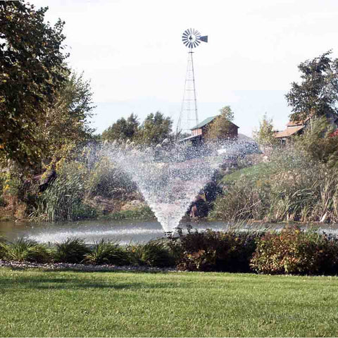 Kasco 1HP Aerating Fountain 4400VFX with V-Shape Pattern Operating in a Pond Surrounded by Plants and a Windmill 115V/230V