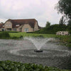 Image of Kasco 3/4HP Aerating Fountain 3400VFX with V-Shape Pattern Operating in a Pond with a Brown House at the Back