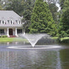 Image of Kasco 3/4HP Aerating Fountain 3400VFX with V-Shape Pattern Operating in a Pond in Front of a  White House with Trees